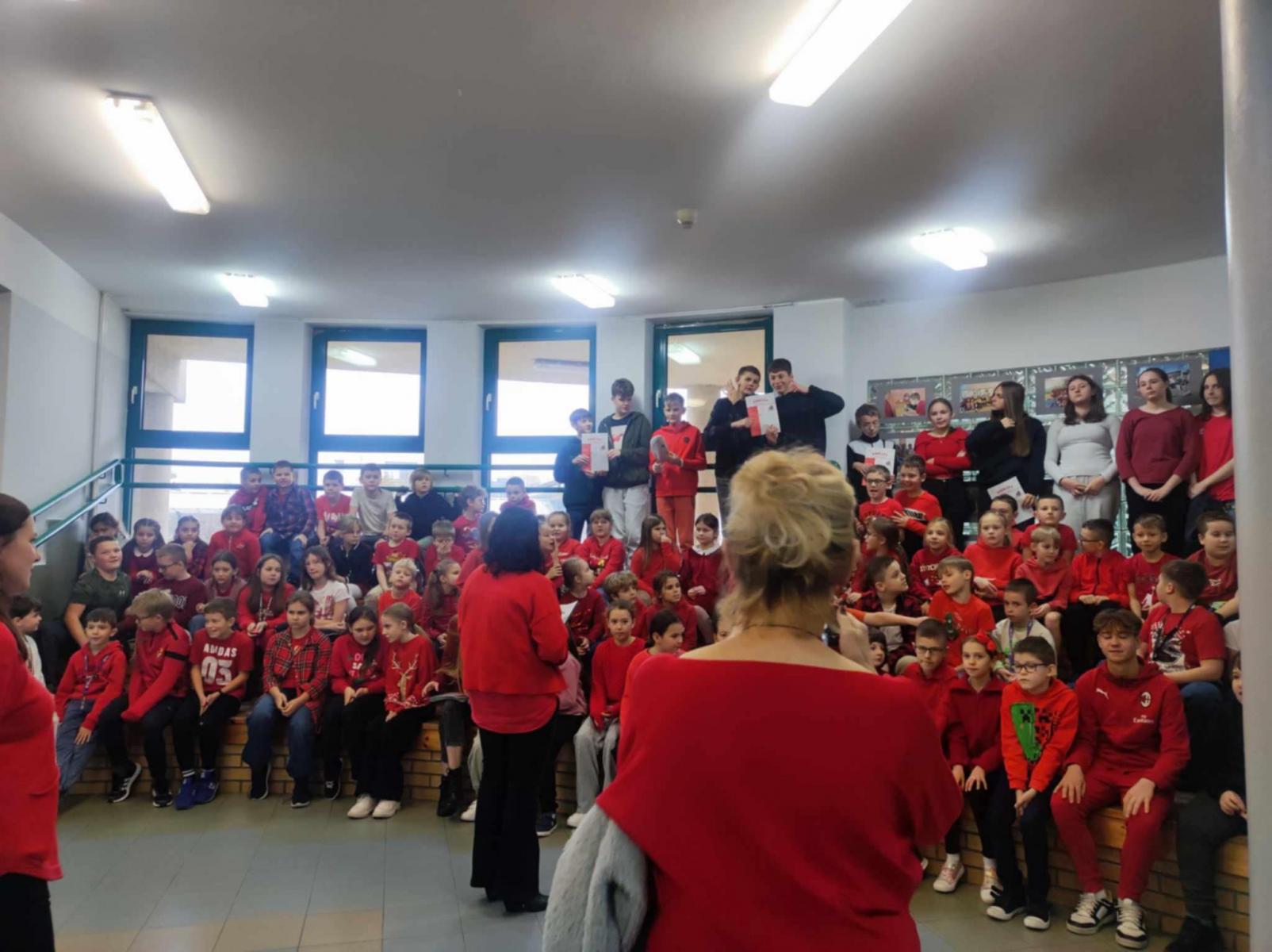 Uczniowie ze szkoły pozują ubrani na czerwono